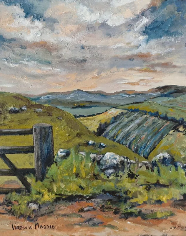A wooden gate and stone wall in the foreground, green hills and striped fields rolling away to distant hills under a blue and pink sky