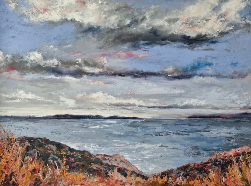 Light breaking across the grey water of the Forth, seen from a rust coloured headland, under bands of dark and pale cloud